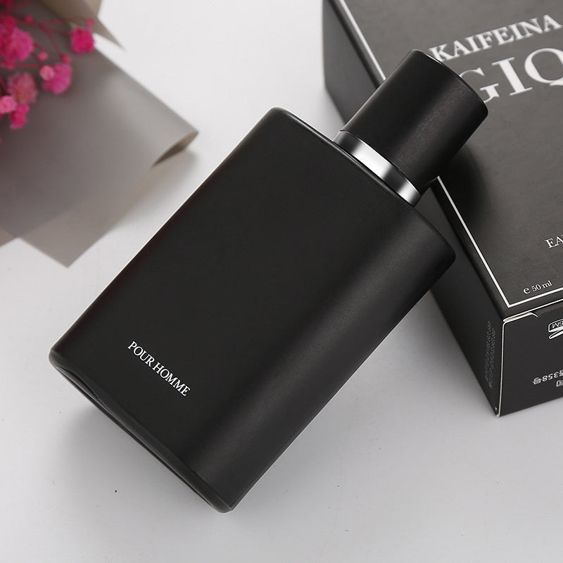 Black perfume bottle with 'Four Homme' text on a white surface, next to a black box.