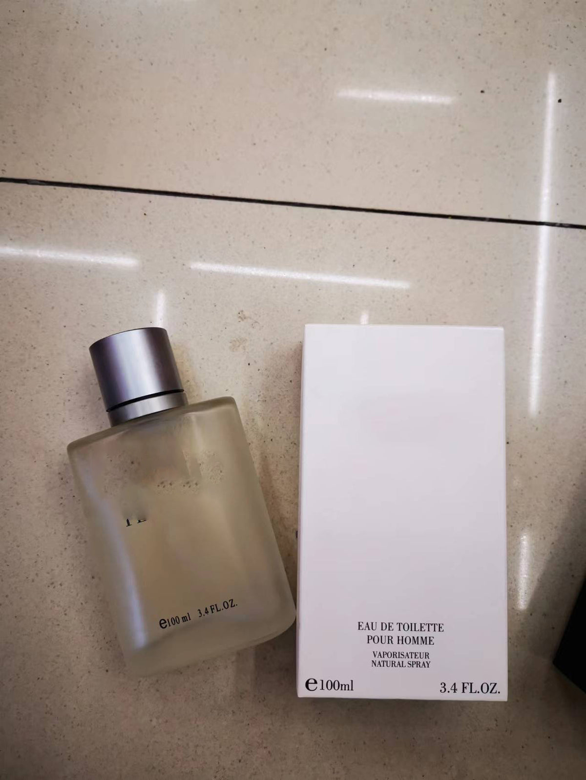 Perfume bottle and packaging on a light-colored surface